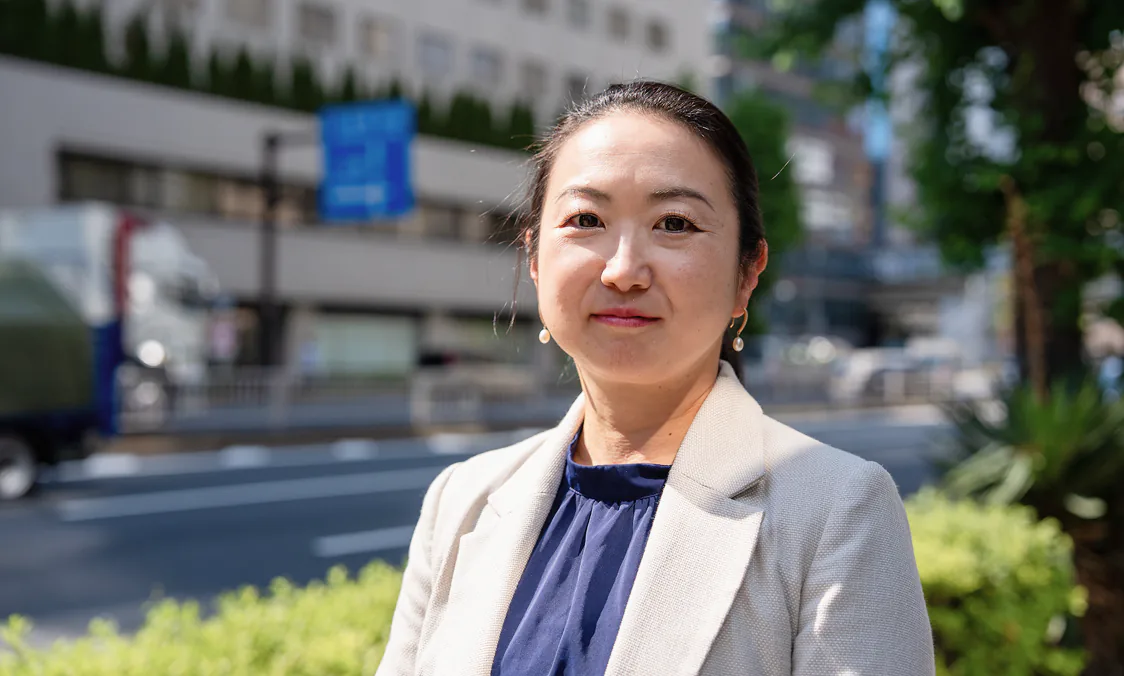 オフィスの屋外に立つ女性社員