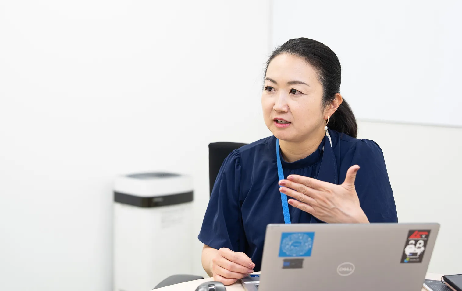 打ち合わせで説明する社員