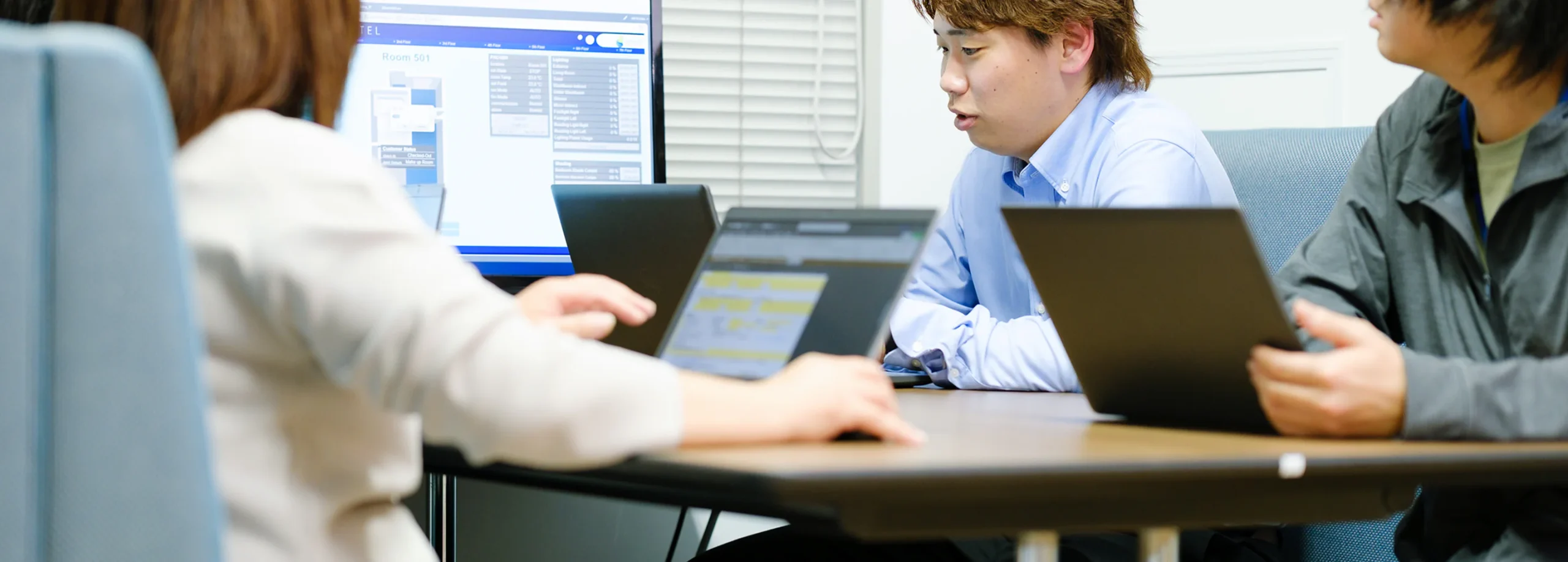 ノートパソコンを使って打ち合わせをする社員
